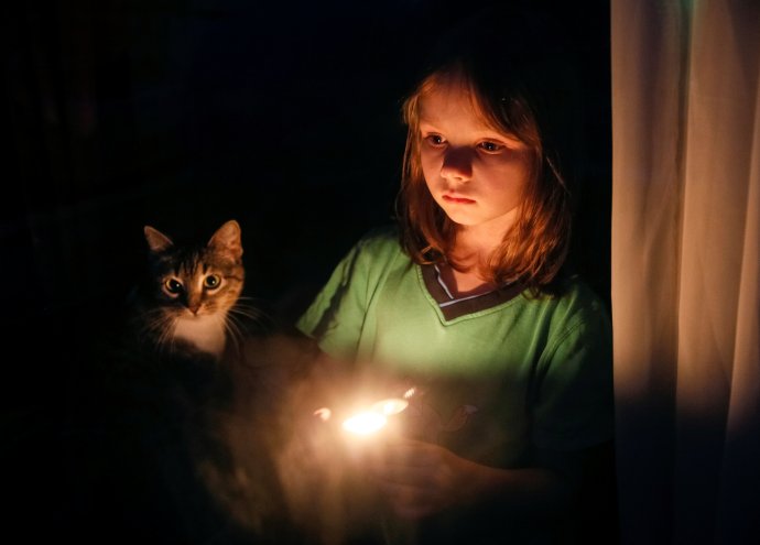 Dívka v okně zapálila svíčku na památku miliónů obětí hladomoru na Ukrajině v letech 1932–33. Kyjev 2016. Foto: Gleb Garanič, Reuters