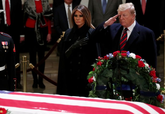 Donald Trump salutuje po boku své ženy Melanie rakvi prezidenta George Bushe v rotundě Capitolu ve Washingtonu. Prezidentský pár přijel vzdát poctu zemřelému prezidentovi v noci. Foto: Jonathan Ernst, Reuters