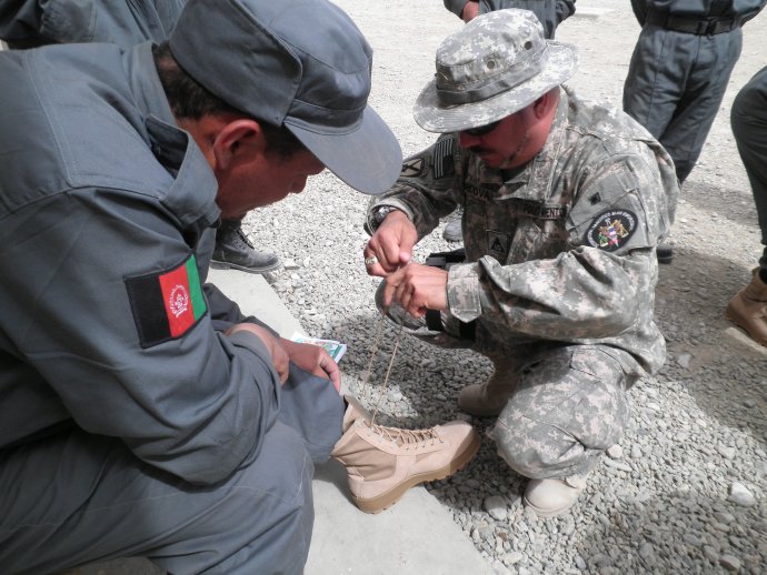 Americký instruktor v Afghánistánu pomáhá místnímu vojákovi správně nosit vojenskou výstroj. Foto: Paikar Paikar