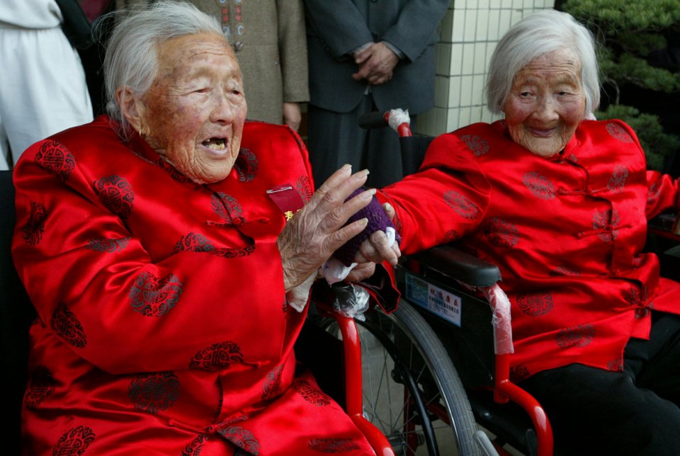 V čínském "městě dlouhověkosti" Žu-kau: kamarádky Wang Min-š' (98 let) a Ting Jü-šen (104 let). Foto: Reuters