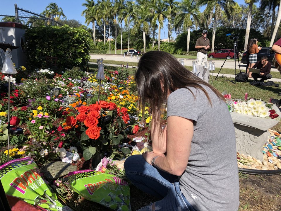 Žena se sklání před místem, kam po roce od střelby ve škole přinášeli lidé květiny jako vzpomínku na padlé studenty a učitele. Foto: Jana Ciglerová