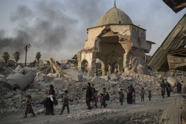 Iráčtí civilisté prchají z Mosulu kolem těžce poškozené mešity an-Núrí. Foto: ČTK