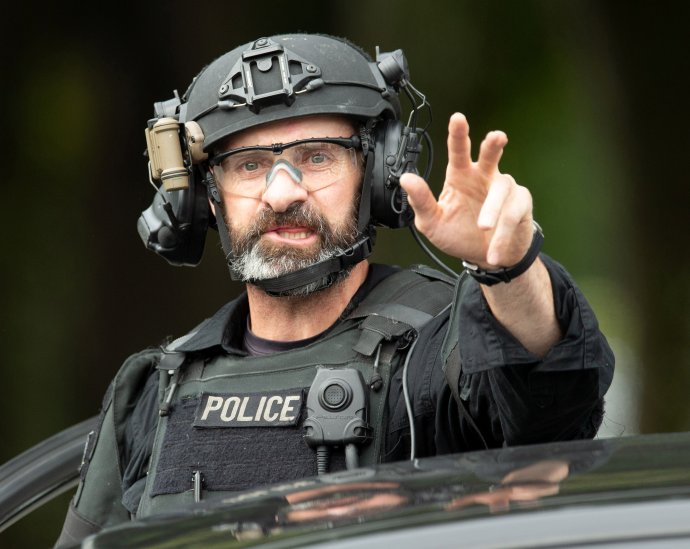 Příslušník speciálního policejního oddílu AOS (Armed Offenders Squad) vydává pokyny před místem atentátu, mešitou Al-Noor ve městě Christchurch. Foto: Martin Hunter, Reuters, SNPA