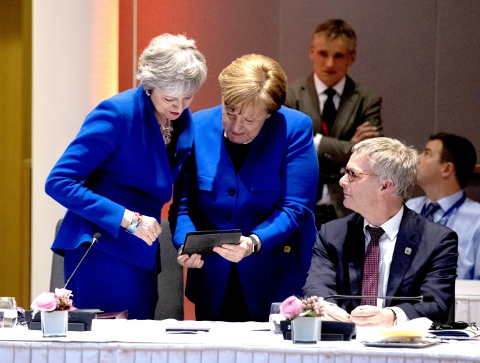 Ještě když bylo veselo: před začátkem mimořádného summitu EU o druhém odkladu brexitu kancléřka Merkelová ukázala premiérce Mayové cosi v iPadu, co ji pobavilo. Po spekulacích, o co šlo, se novináři dozvěděli, že na displeji byl obrázek, jak během dne obě řečnily ve svých parlamentech v těchto modrých šatech. Foto: European Union