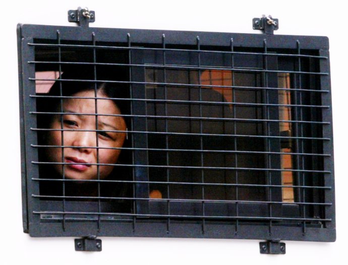 Vydírání, hazard, obchod s lidmi: tradiční obory triád. Na snímku prostitutka z pevninské Číny, zadržená při policejní operaci proti triádám v září 2002. Foto: Bobby Yip, Reuters