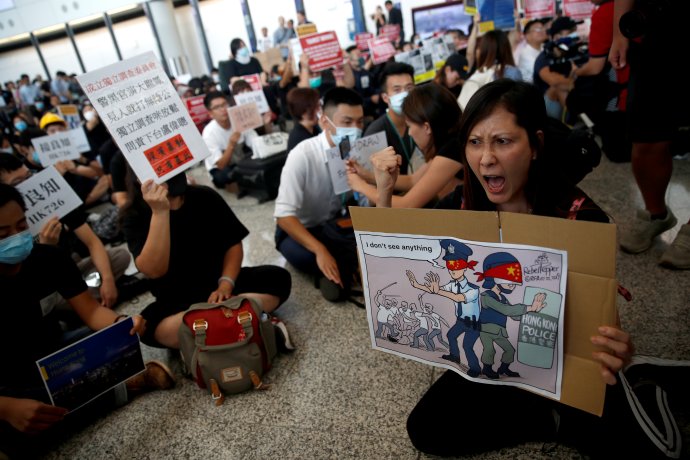 Páteční protest na hongkongském letišti proti násilí v Yuen Longu. Lidé policii vyčítají, že proti násilníkům záměrně nezasáhla - viz transparent. Foto: Edgar Su, Reuters