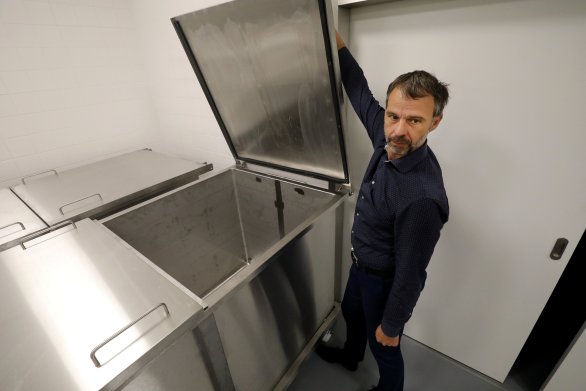 Profesor David Kachlík v suterénu anatomického ústavu. Do kádě, kterou ukazuje, se vejdou čtyři mrtvá těla. Foto: Ludvík Hradilek, Deník N