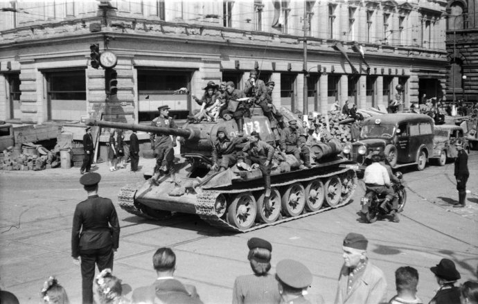 Milovaní i zatracovaní. Sovětští vojáci krátce po svém příjezdu do Prahy v květnu 1945 projíždějí kolem kavárny Slavia, za okupace přejmenované na Café Viktoria. Foto: ČTK