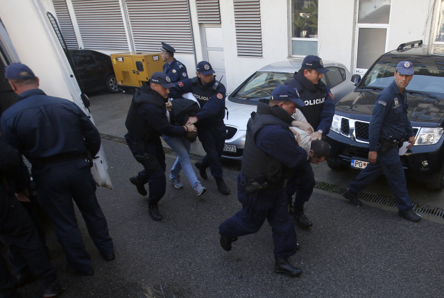 Policie v Černé Hoře eskortuje lidi, kteří jsou podezřelí z účasti na pokusu o převrat (2016). Foto: ČTK