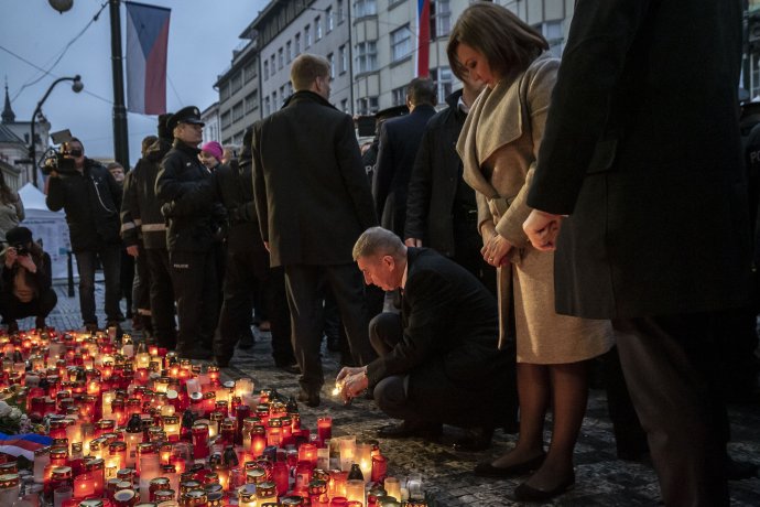 Premiér zapaloval svíčky u desky připomínající 17. listopad 1989 v ranním šeru, za přítomnosti ochranky a policie v počtu převyšujícím ostatní návštěvníky piety, kteří ho vyprovodili pískotem. Foto: Gabriel Kuchta, Deník N