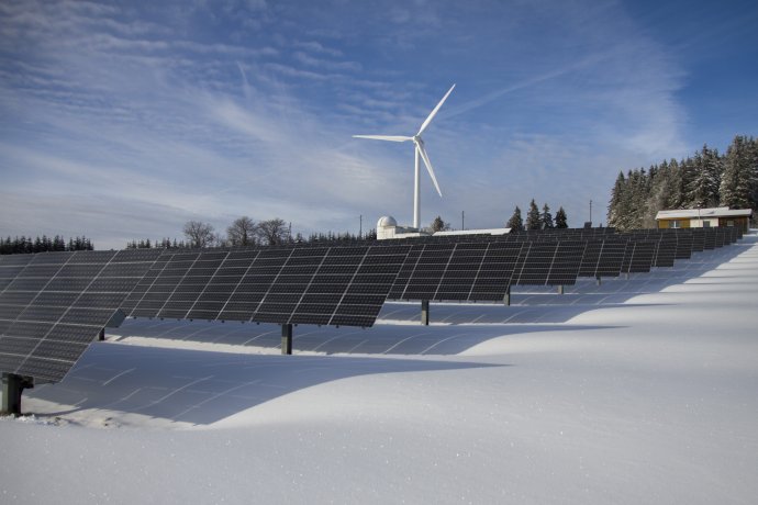 Solární panely a větrná elektrárna na sněhu. Foto: Pexels