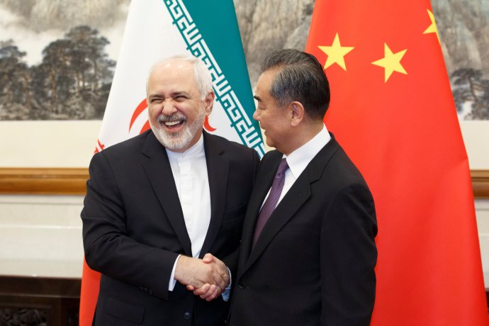 Čínský ministr zahraničí Wang I vítá svého íránského kolegu Mohammada Džaváda Zarífa v konferenčním sále pětihvězdičkového hotelu Tiao-jü-tchaj v Pekingu. Jen loni se oba vrcholoví diplomaté sešli hned čtyřikrát. Foto: Thomas Peter, Reuters
