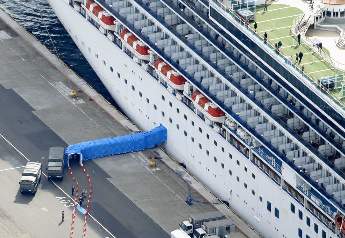 Japonské úřady zahájily propouštění prvních pasažérů z karantény na lodi Diamond Princess v Jokohamě. Asi 500 cestujících s negativním testem na koronavirus 2019-nCoV prošlo modrým tunelem z lodi do připravených autobusů. Žádná další karanténa už je nečekala. Foto: Kjódó via Reuters