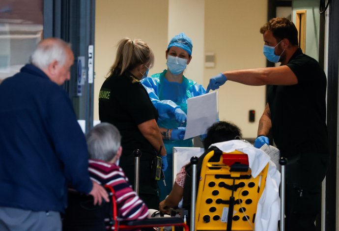Zdravotníci a pacienti ve vchodu liverpoolské Aintree University Hospital během koronavirové krize v Británii, 23. dubna 2020. Foto: Phil Noble, Reuters