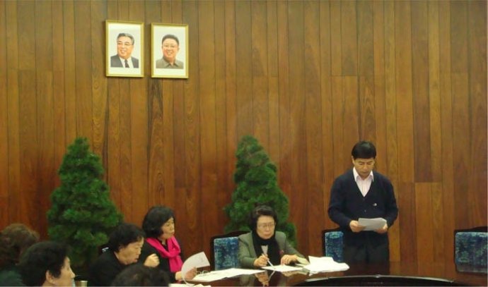 Čchö Un-bok (v černé šále a zeleném saku) předsedá schůzi Generální asociace Korejců v Číně (Pektu Hanna), prominentního sdružení napojeného na KLDR (archivní snímek z roku 2013). Foto: Pektu Hanna via NK News