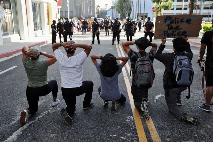 Long Beach v Kalifornii a protestující proti zabití George Floyda s nápisem, který lze volně přeložit jako Udělejte pořádek v policii. Foto: Patrick Fallon, Reuters