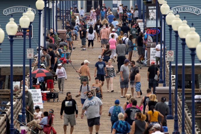 Američané za sílící pandemie u pláže v kalifornském Oceanside. Většina z nich bez roušek. Foto: Mike Blake, Reuters