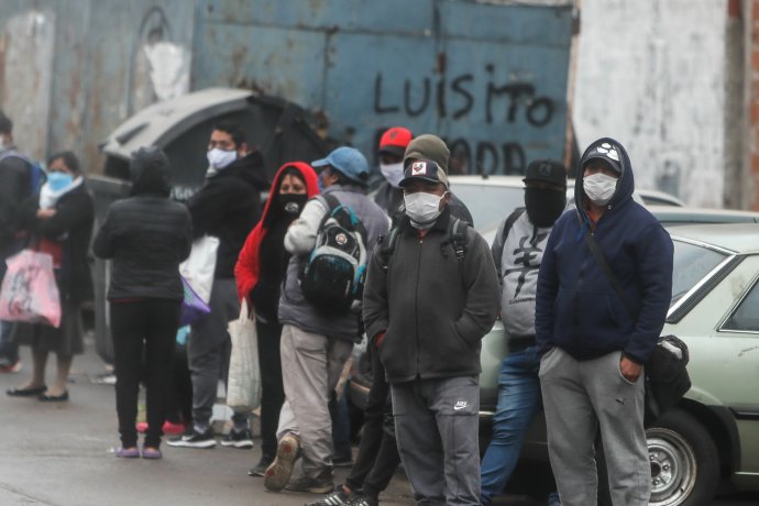 Lidé v jedné z chudinských čtvrtí Buenos Aires čekají ve frontě na talíř polévky, kterou pro ně během koronavirové karantény připravují dobrovolníci. ČTK / EFE / Juan Ignacio Roncoroni