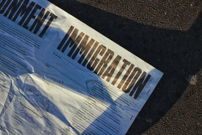 Leták s návrhy britských politických stran na řešení přistěhovalectví, povalující se na londýnské Westminster Bridge Road. Foto: Metin Ozer, Unsplash
