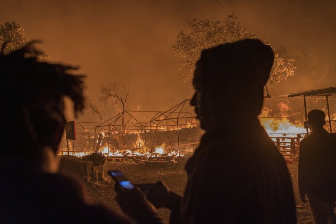Uprchlíci pozorují požár, který likviduje stany v táboře Moria. Foto: Murat Türemis