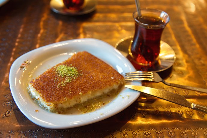 Turecký dezert künefe s pistáciemi, v restauraci tradičně servírovaný s čajem. Foto: Adobe Stock