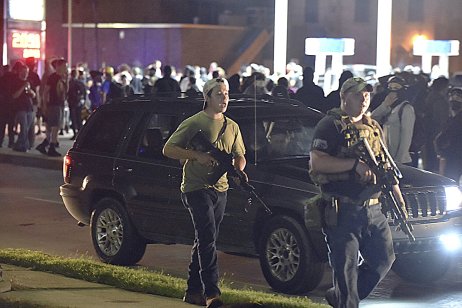 Kyle Rittenhouse (vlevo) spolu s dalším ozbrojeným civilistou ulicí města Kenosha krátce předtím, než zastřelil dva muže a dalšího zranil. Foto: ČTK / The Journal Times via AP