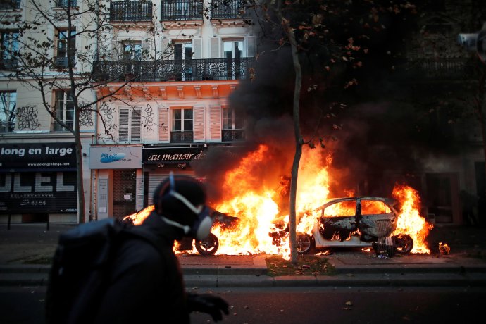 Hořící auta během pařížské demonstrace proti zákonu o globální bezpečnosti, který měl podle kritiků kriminalizovat zveřejnění a šíření fotografií zobrazujících zasahující policisty. Paříž, sobota 28. listopadu 2020. Foto: Benoit Tessier, Reuters
