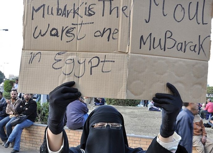 Egypťanka na káhirském Tahríru v lednu 2011 s nápisy Mubárak je v Egyptě nejhorší a Odejdi, Mubaraku. Foto: Floris Van Cauwelaert, Wikimedia Commons, CC BY-SA 2.0