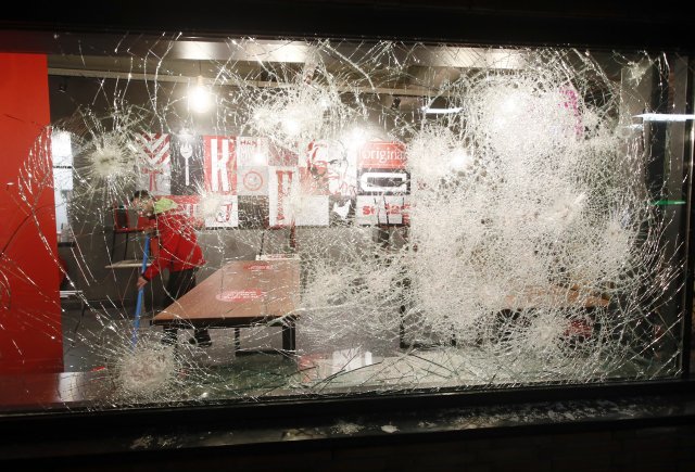 Rozbitá výloha restaurace v Rotterdamu během nocí protestů proti zákazu vycházení v Nizozemsku. Foto: Peter Dejong, AP/ČTK