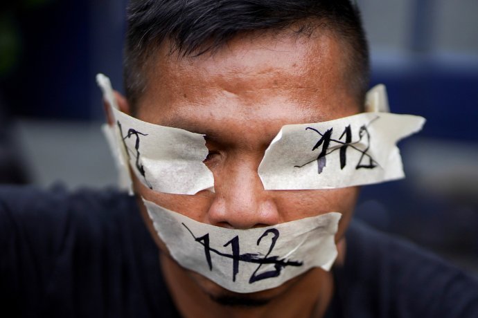 Pod číslovkou 112 se skrývá článek thajského trestního zákoníku, který prohlašuje urážku královského majestátu za zločin s trestní sazbou až 15 let odnětí svobody. Snímek pochází ze sobotní demonstrace před soudem v Bangkoku za zrušení článku 112 a propuštění vězněných prodemokratických aktivistů. Foto: Athit Perawongmetha, Reuters