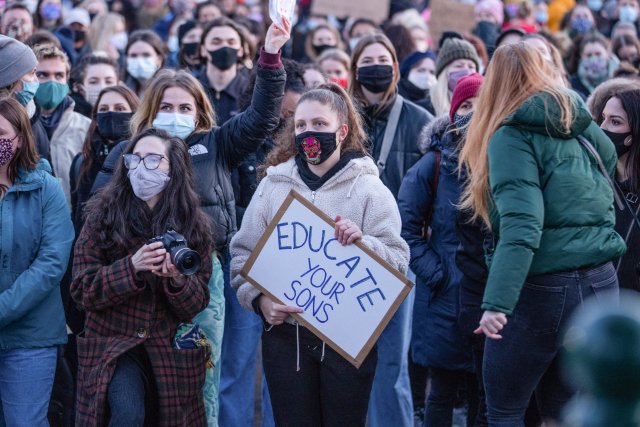 Jedna ze stovek žen, které do Clapham Common dorazily protestovat proti násilné smrti Sarah Everardové, nese v rukou transparent s výzvou: „Vzdělávejte své syny.“ Upozorňuje na to, že pachateli násilí na ženách jsou ve většině případů muži. Foto: Phil Lewis, ČTK