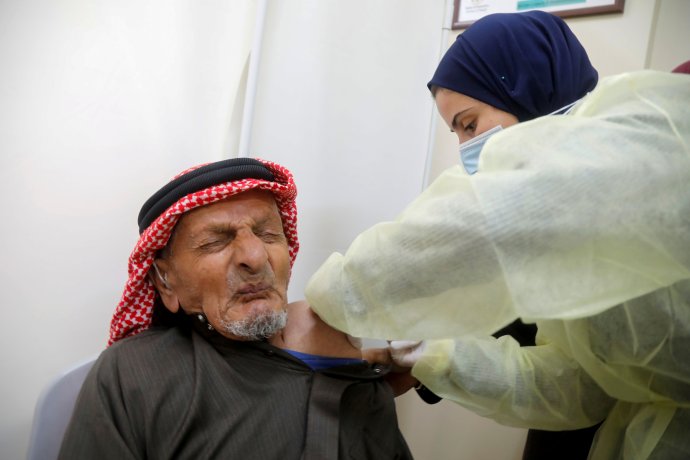 Palestinec, jehož zdravotní sestra ve městě Túbás na Izraelem okupovaném Západním břehu Jordánu očkuje vakcínou AstraZeneca proti nemoci covid-19. Foto: Ranín Sawafta, Reuters