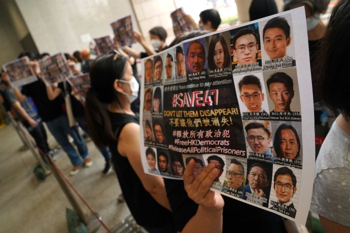 Lidé drží transparenty na podporu 47 prodemokratických aktivistů obžalovaných z porušení zákona o státní bezpečnosti, kteří dnes stojí před soudem (31. května 2021). Foto: Lam Yik, Reuters