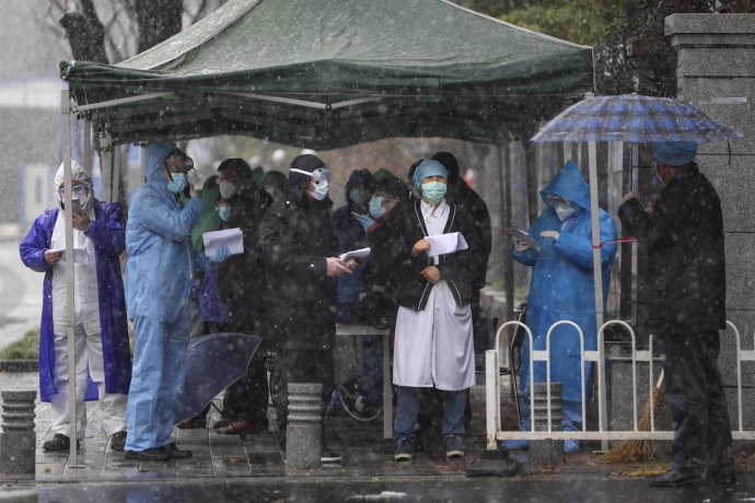 Před onkologickou klinikou ve Wu-chanu, nouzově předělanou na covidovou nemocnici, čekají 15. února 2020 zdravotníci a úředníci na pacienty. Foto: ČTK