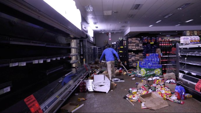 Jeden z obyvatel jihoafrického Durbanu, kteří ozbrojeni a na vlastní pěst vyhledávají lidi rabující v místním nákupním centru. Foto: Kierran Allen via Reuters