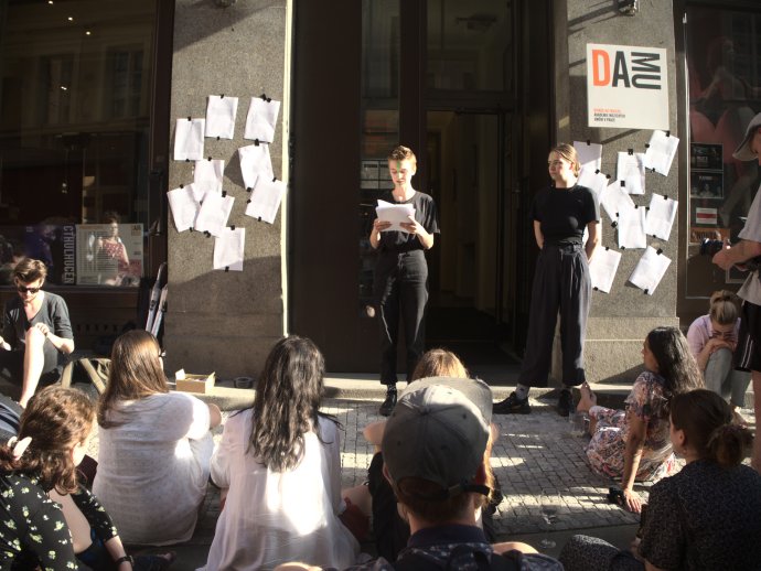 Členka iniciativy Ne!musíš to vydržet čte před vchodem DAMU příběhy svých spolužaček a spolužáků. Foto: Ne!musíš to vydržet