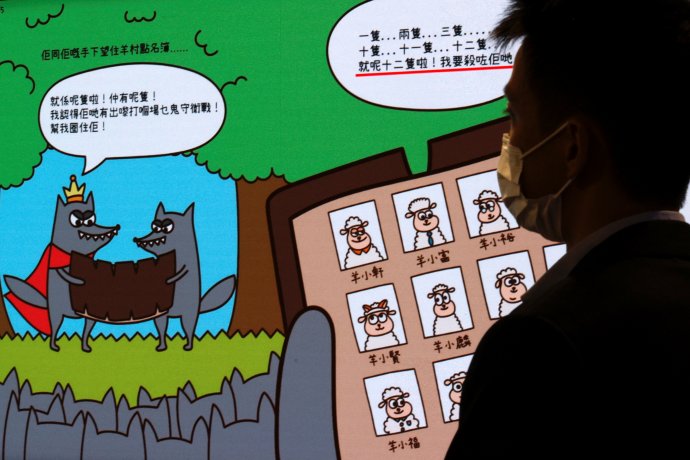 Tisková konference hongkongské státní bezpečnosti a výňatek z dětské obrázkové knížky Strážci ovčí vesnice. Na hongkongském knižním veletrhu už čelila útokům i Orwellova Farma zvířat: také ona prý podněcuje separatistické pudy. Foto: Tyrone Siu, Reuters