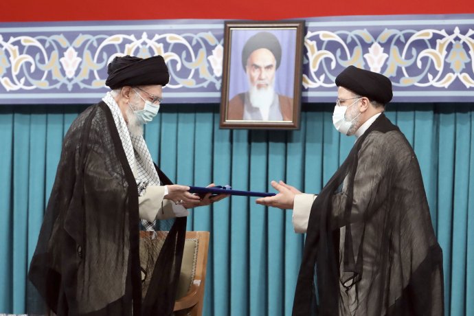 Výběr Raísího (na snímku vpravo) do prezidentského úřadu v úterý oficiálně potvrdil nejvyšší duchovní vůdce země ajatolláh Alí Chameneí (vlevo) za přísného dohledu otce íránské revoluce, ajatolláha Chomejního (portrét). Foto: ČTK/AP