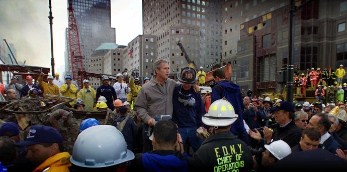 Třetí den po útoku na budovu newyorského WTC v září 2001 přišel mezi vyčerpané záchranáře tehdejší prezident George W. Bush. Jeho projev slibující odvetu všem, kdo měli se sebevražednými leteckými údery něco společného, jako by předznamenal zahraničněpolitické kroky USA v nadcházejících dvaceti letech. Foto: ČTK/AP