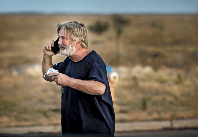 Zdrcený Alec Baldwin telefonuje poté, co byl po osudném výstřelu, kterým zabil kameramanku Halynu Hutchins, vyslechnut policií. Foto: Jim Weber, ČTK/AP