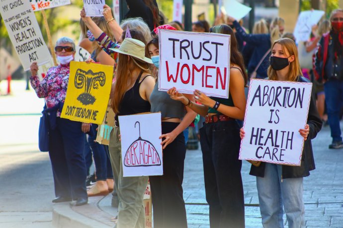 „Důvěřujte ženám,“ hlásá nápis na transparentu žen, které protestují proti zákazu interrupcí v USA. Od jeho uzákonění Texasanky zaplnily interrupční kliniky v okolních státech. Foto: Manny Becerra, Unsplash