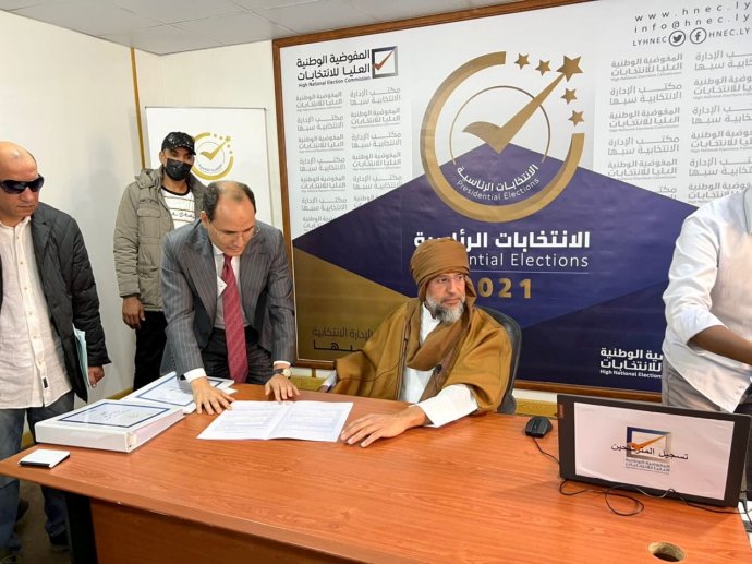 Sajf al-Islám Kaddáfí (u stolu) se registruje jako prezidentský kandidát v jiholibyjském městě Sebhá (14. listopadu 2021). Foto: Khaled Al-Zaidy via Reuters