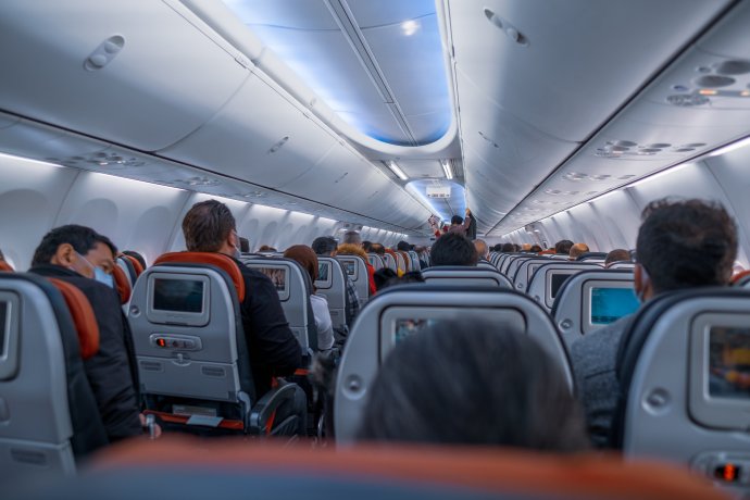 Pasažéři s rouškami v letadle. Foto: Oguzhan Dursun, Adobe Stock
