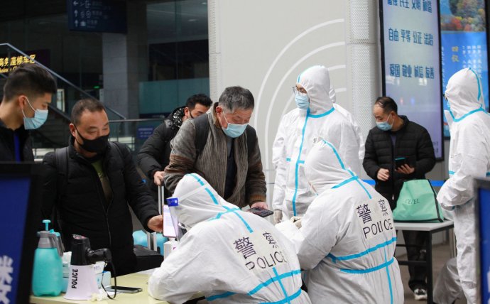 Začátek novoroční cestovní sezony: čínští policisté v ochranných oblecích kontrolují zdravotní průkazy cestujících na vlakovém nádraží, 17. ledna 2022. Foto: China Daily via Reuters