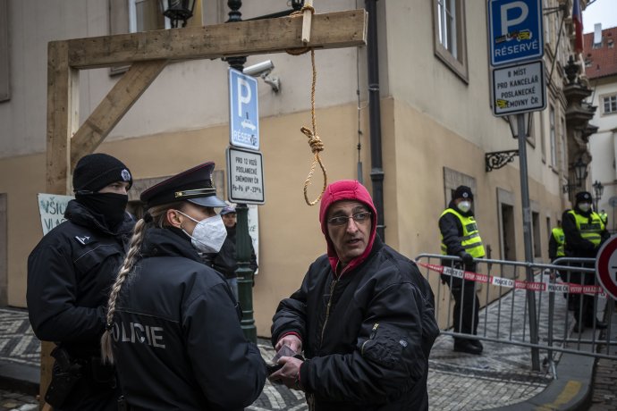 Policisté legitimují muže, který na Malostranské náměstí přivezl šibenici. Foto: Gabriel Kuchta, Deník N