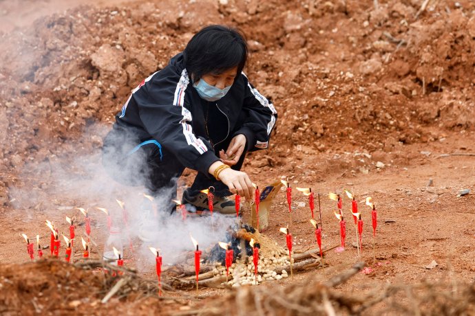 Šedesátiletá Liang zapaluje svíčky během buddhistického obřadu k uctění mrtvých. Vesnické pole, kde je rozestavila, leží v horách nedaleko místa, kde se k zemi zřítil čínský boeing se 132 lidmi na palubě. Foto: Carlos Garcia Rawlins, Reuters