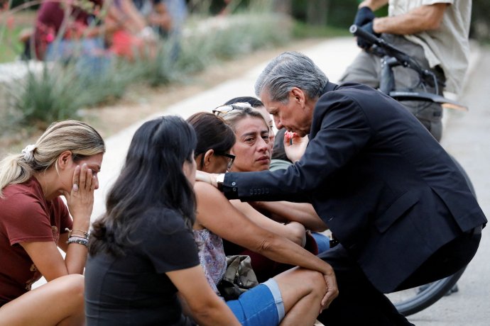 Arcibiskup z texaského San Antonia Gustavo Garcia-Siller utěšuje rodiny zastřelených dětí před veřejným centrem Ssgt Willie de Leon. Tam byly převezeny děti, které přežily masakr v Robbově základní škole v Uvalde. Foto: Marco Bello, Reuters