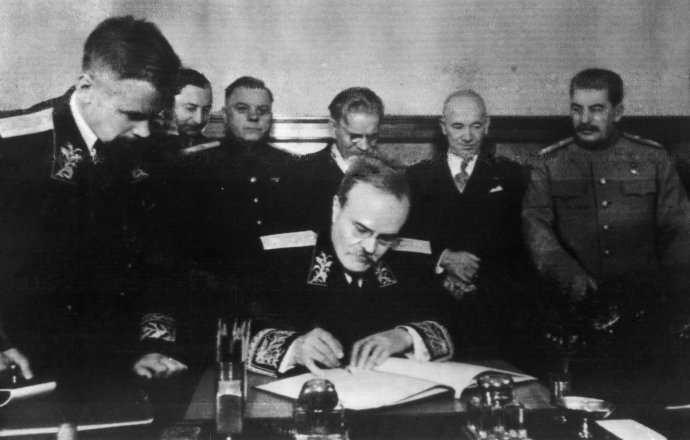 Sovětský ministr zahraničí Molotov podepisuje čs.-sovětskou smlouvu. Za ním zprava Stalin, Beneš, Kalinin, Vorošilov a Fierlinger. Prosinec 1943. Foto: ČTK