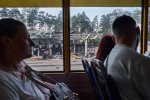 Passengers on marshrutka number 421 look out the window at the gas station that was destroyed by invading Russian forces on the outskirts of Kyiv.