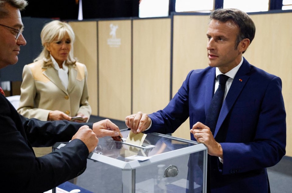Francouzský prezident Emmanuel Macron pozorovaný manželkou vhazuje hlas do urny v Le Touquet při 1. kole parlamentních voleb. Foto: Ludovic Marin, pool via Reuters